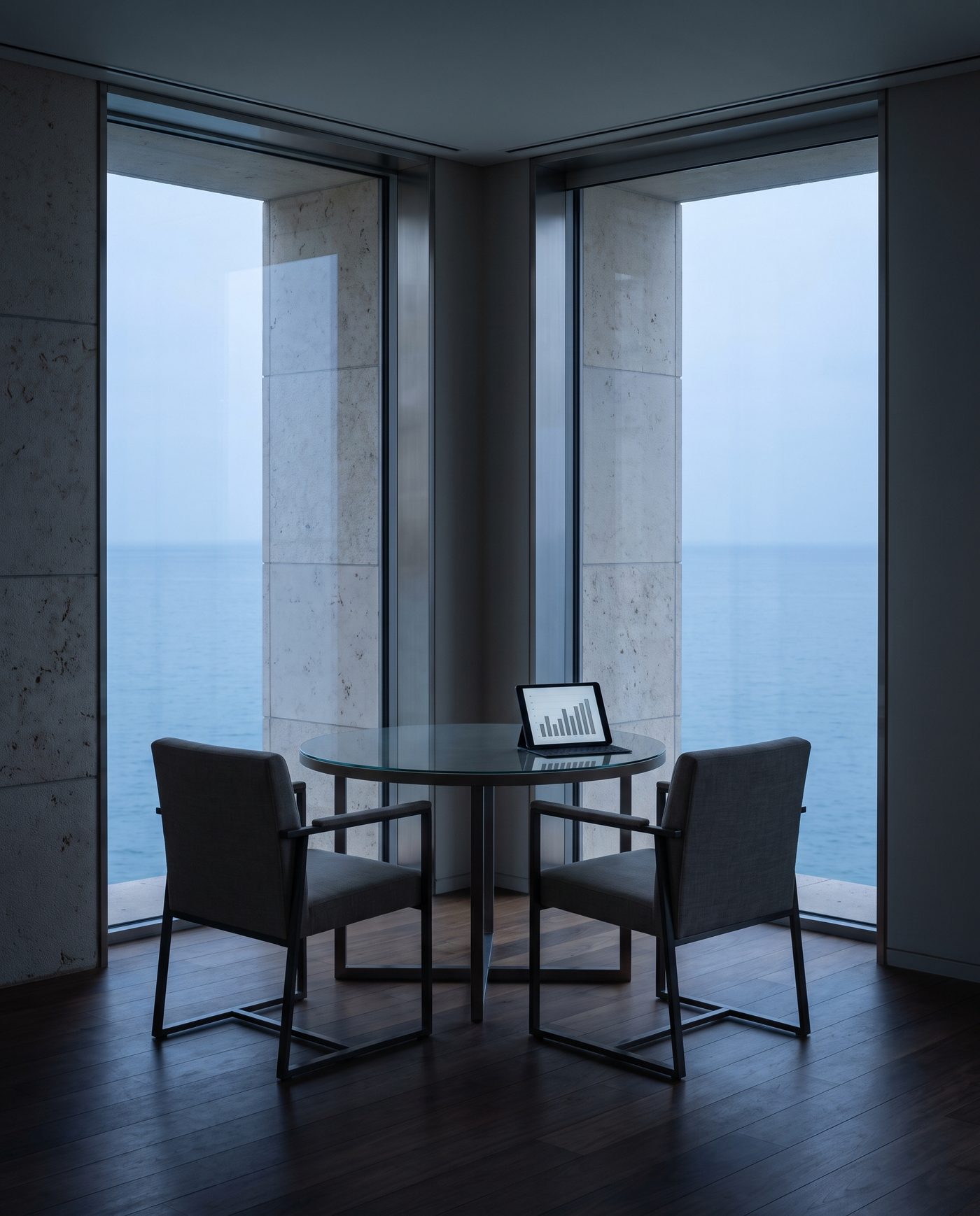 Two chairs at a glass-topped table, a tablet showing a plain chart.
