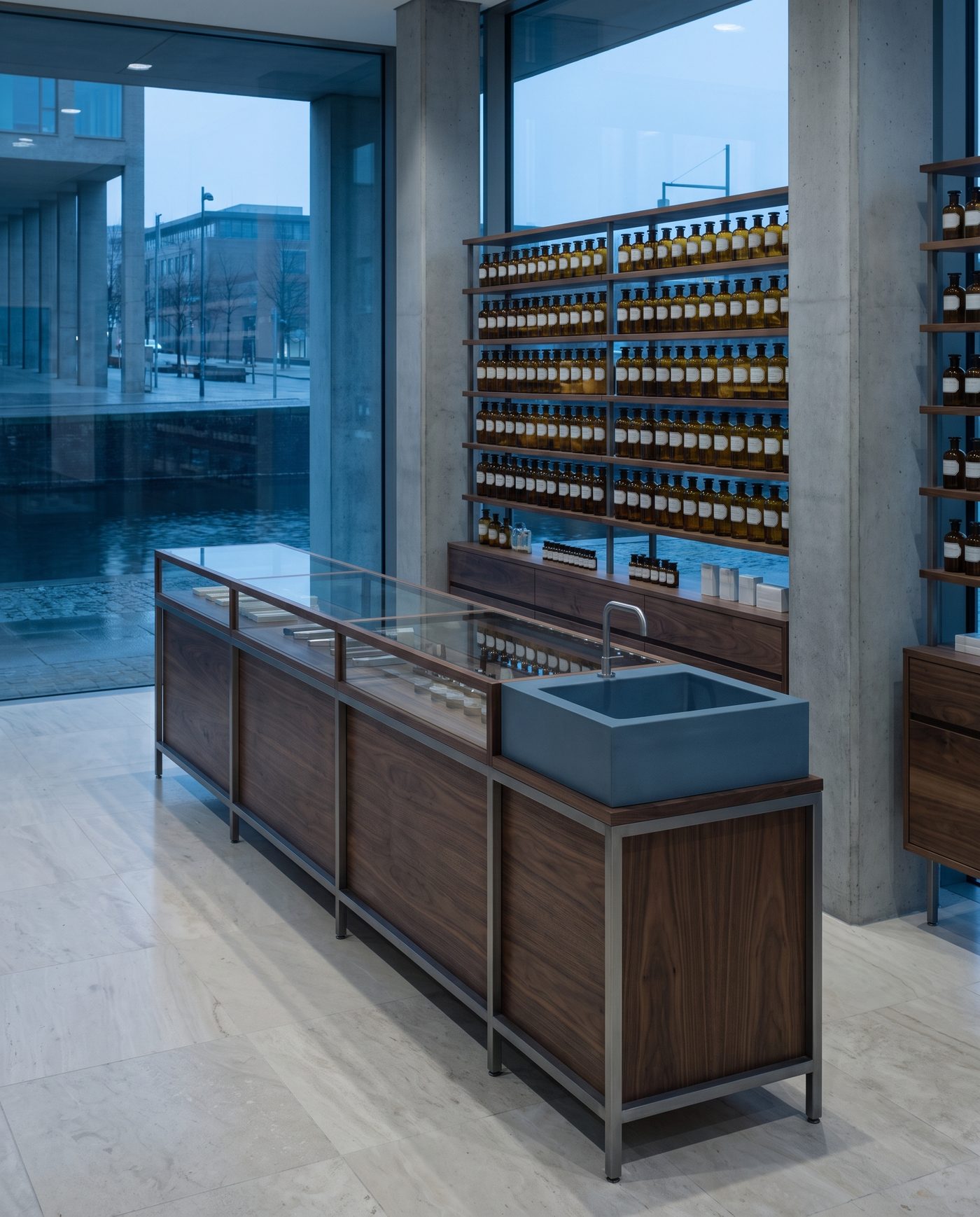 Rows of pale amber bottles evenly spaced behind a glass pharmacy counter.