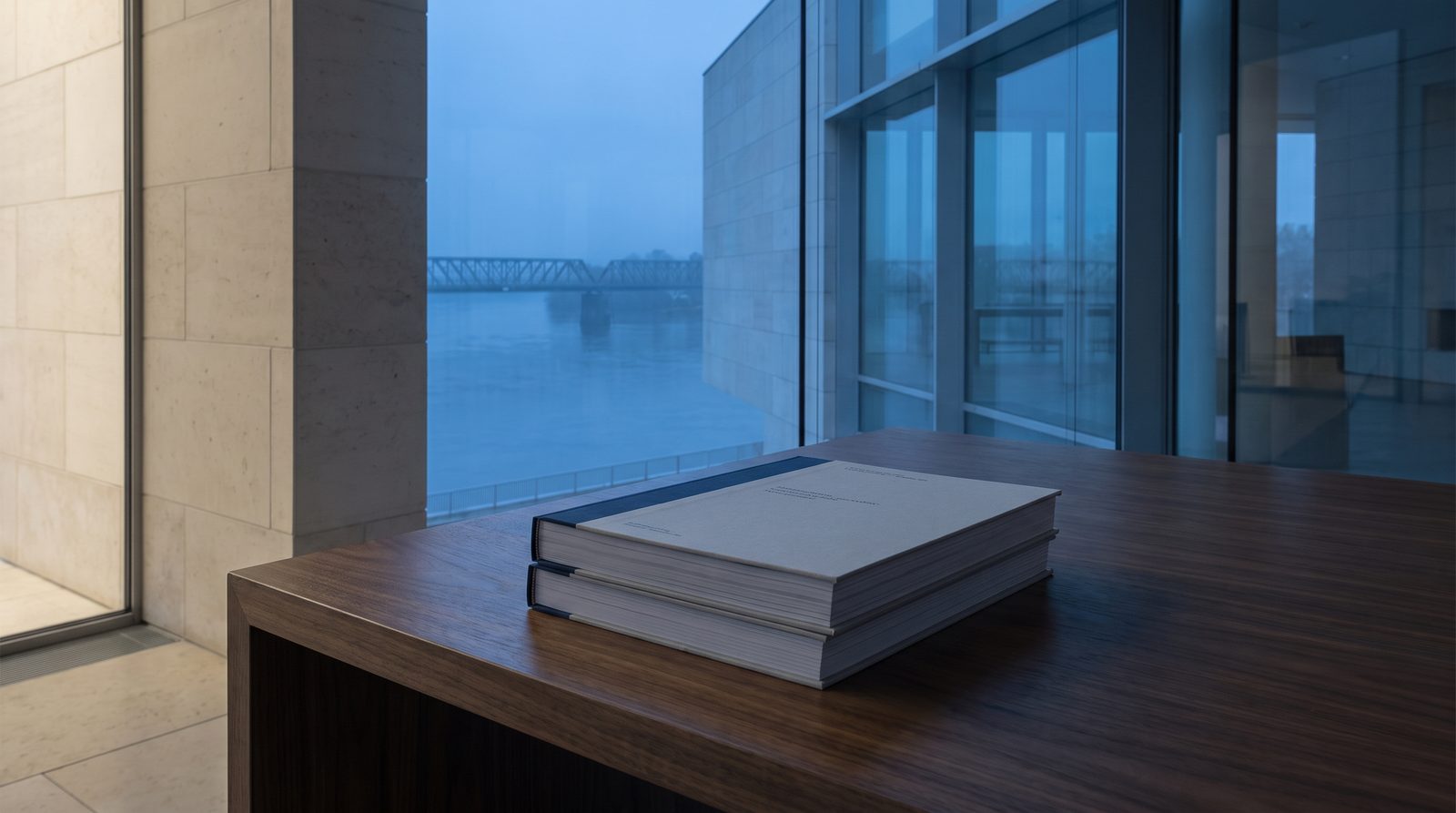 A stack of two reports aligned on a walnut desk, side light.